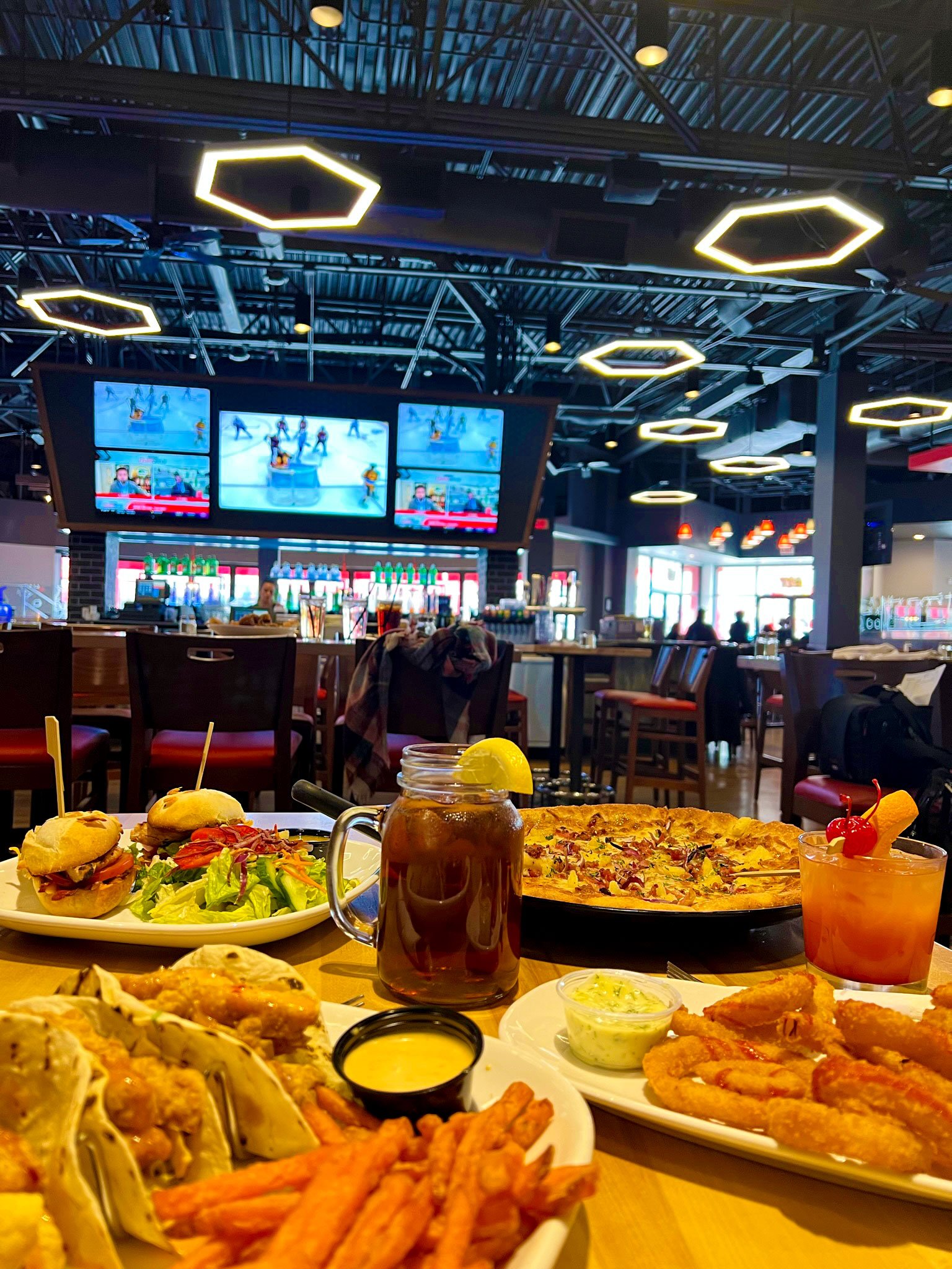 Boston Pizza table with a medley of food with sports bar in background
