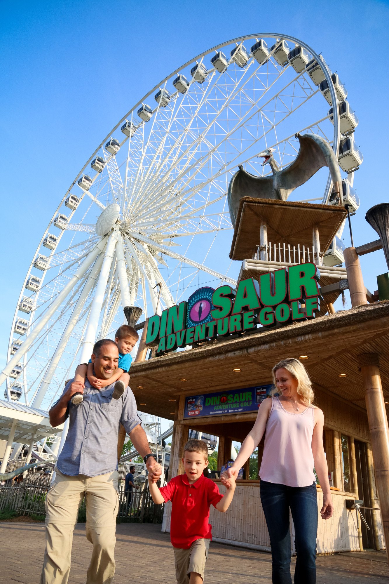 Family in front of Dino Adventure Golf entrance in the daytime