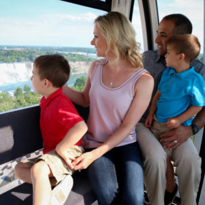 Young family enjoying birds eye view of Niagara Falls from the Niagara SkyWHeel with Clifton Hill Fun Pass