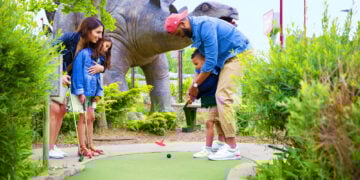 Family Mini Putting Near Large Dinosaurs