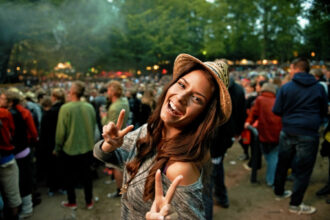 Its all about the vibe. A pretty young woman showing a peace sign at an outdoor music festival.