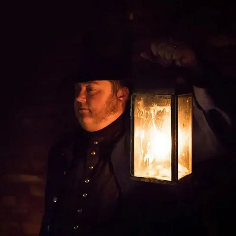 Man holding a candle lit lantern