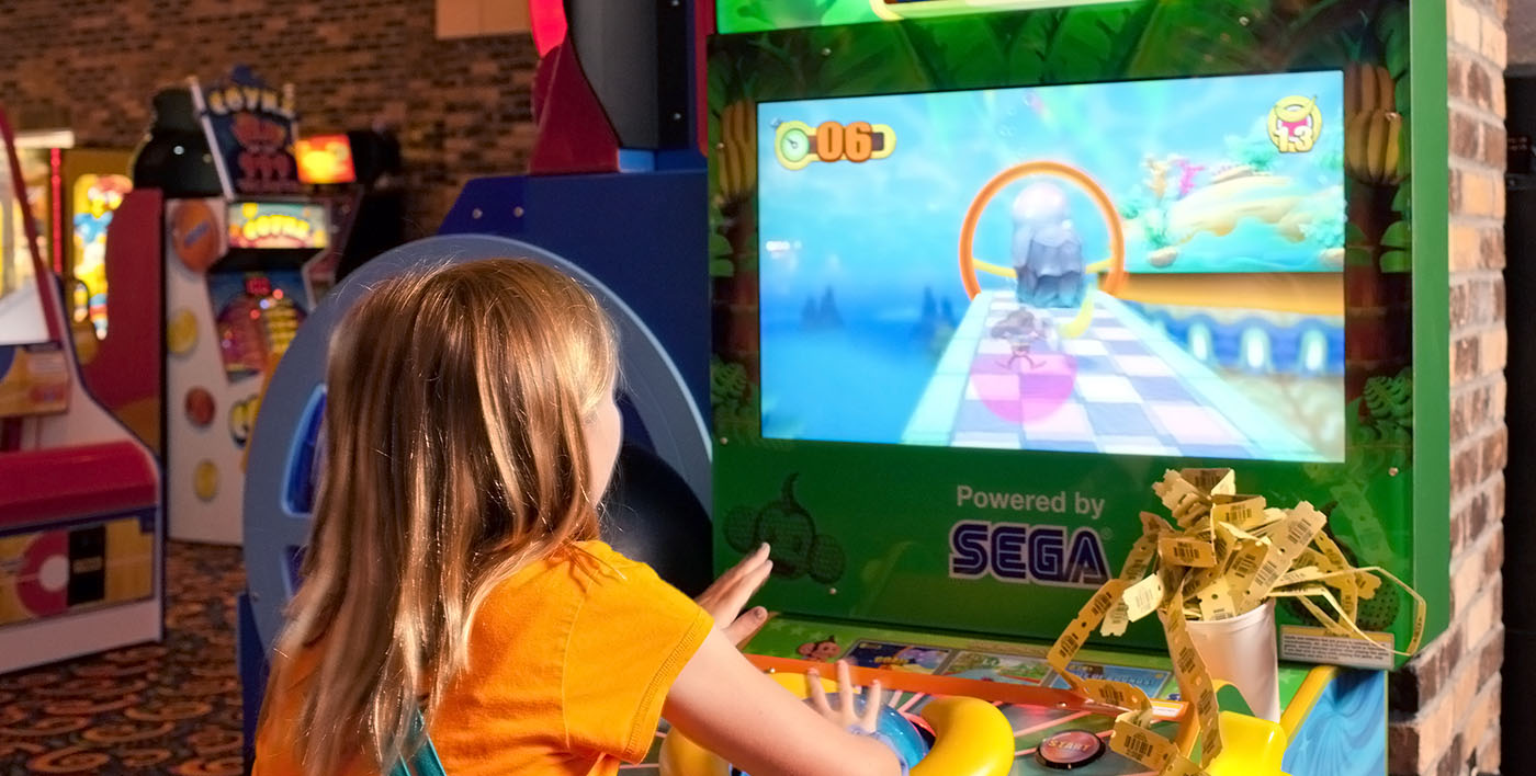 Young girl playing Great Canadian Midway arcade game 