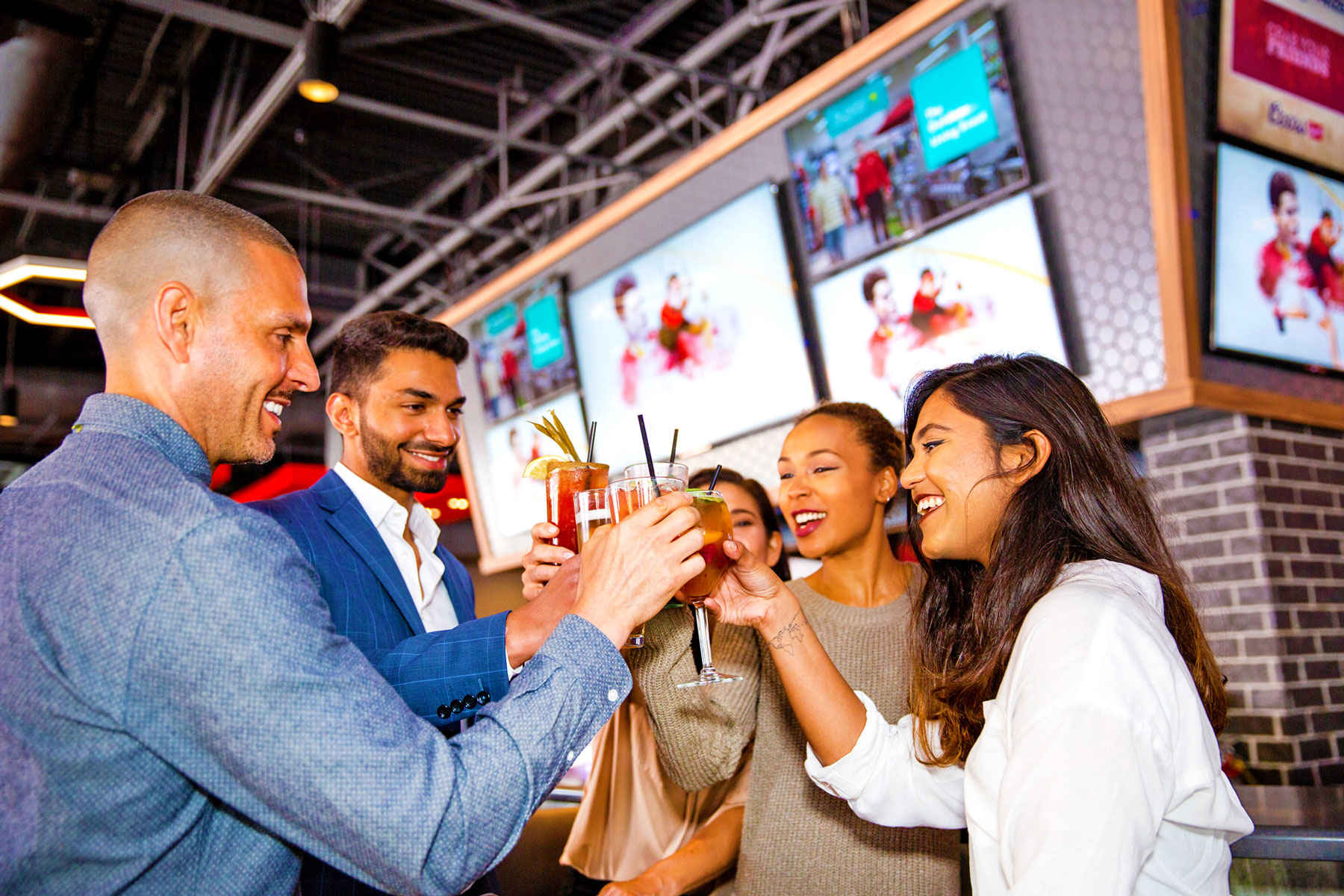 Friends cheering with drinks at boston pizza bar