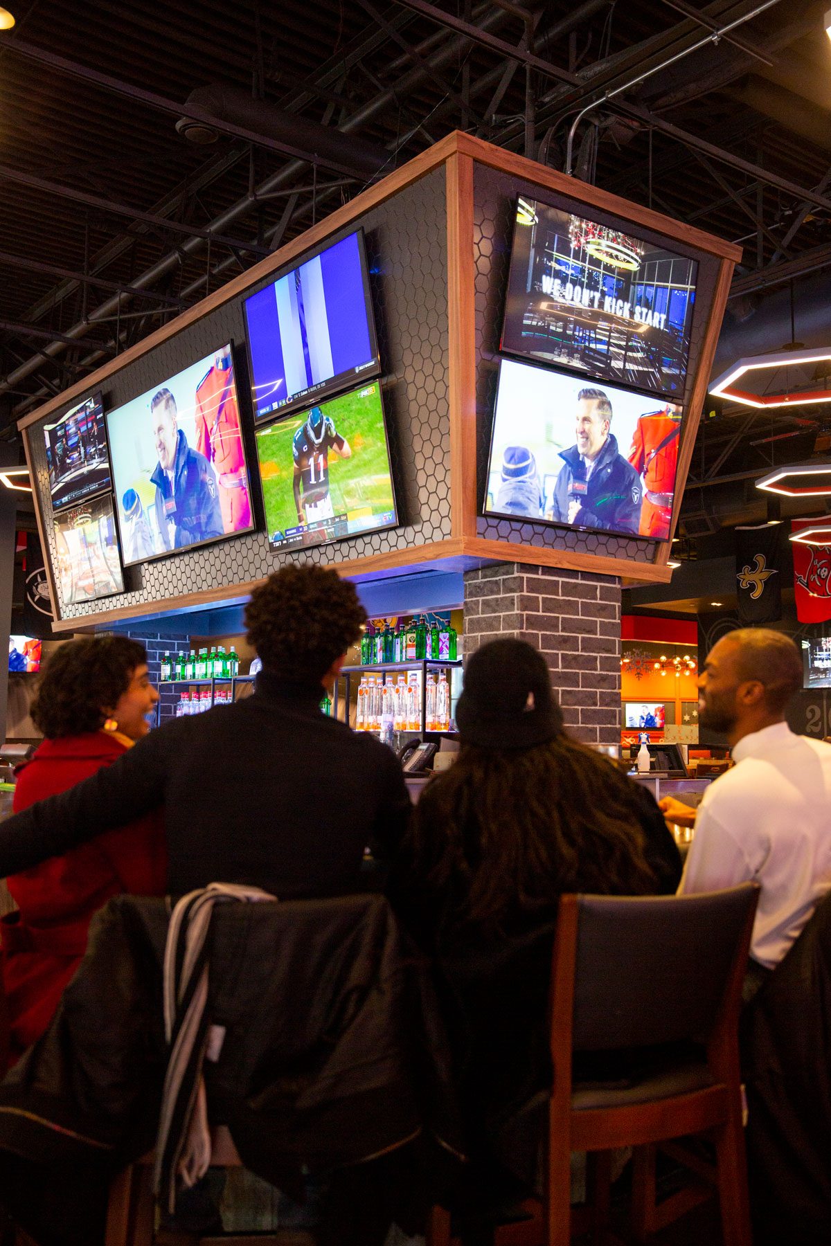 Group of friends watching sports match at bar