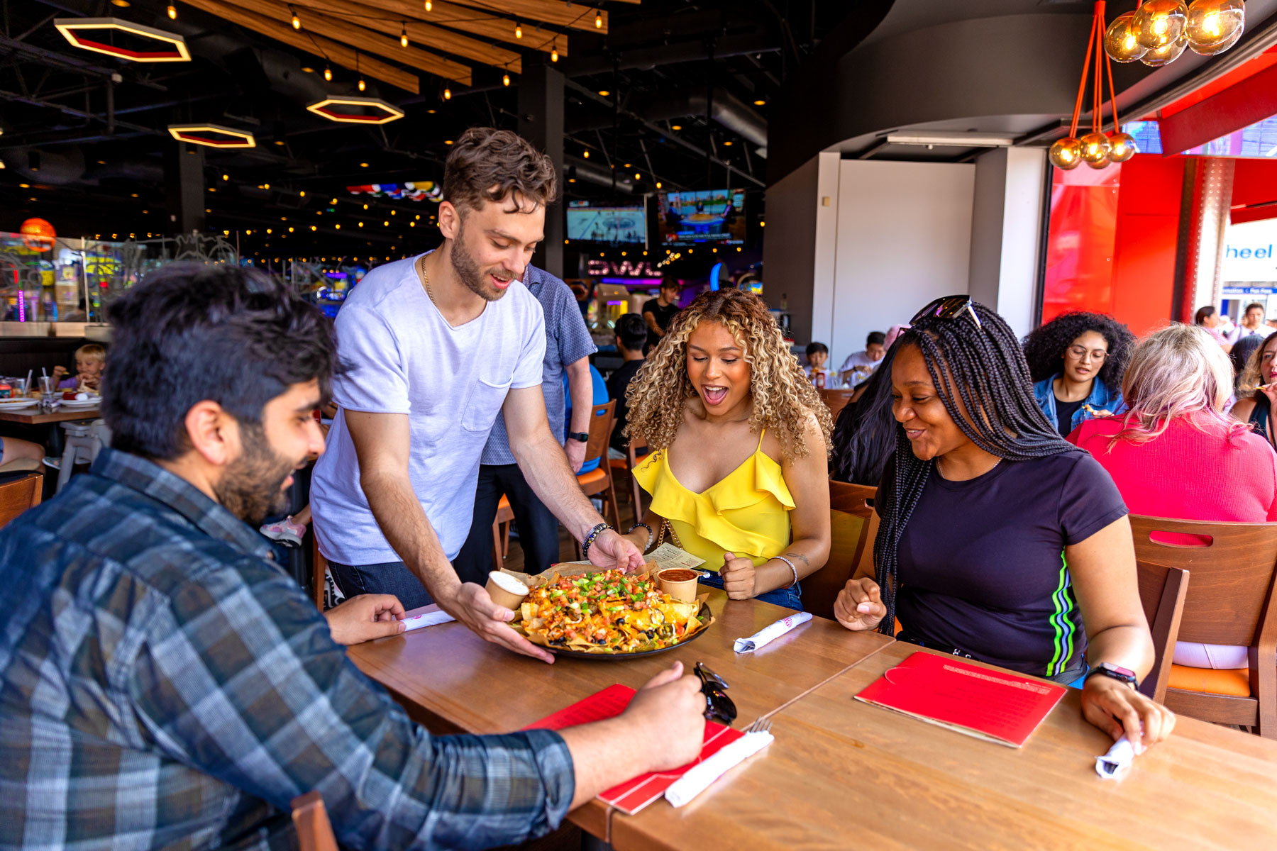 Group of friends being served delisious looking pizza at boston pizza