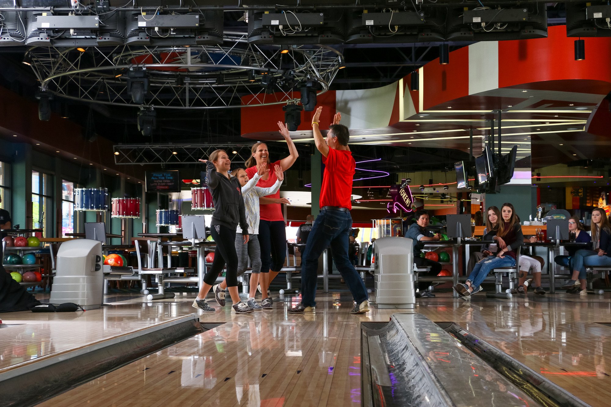 Family cheering after sending bowling ball down lane for a srike