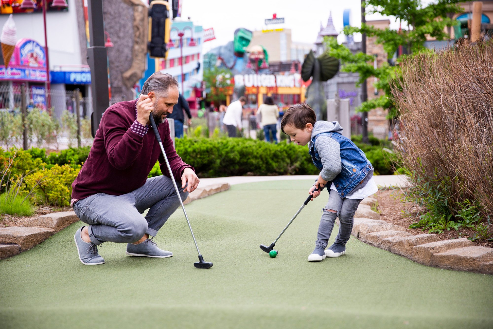 Father and son putting green summer at Dino Golf