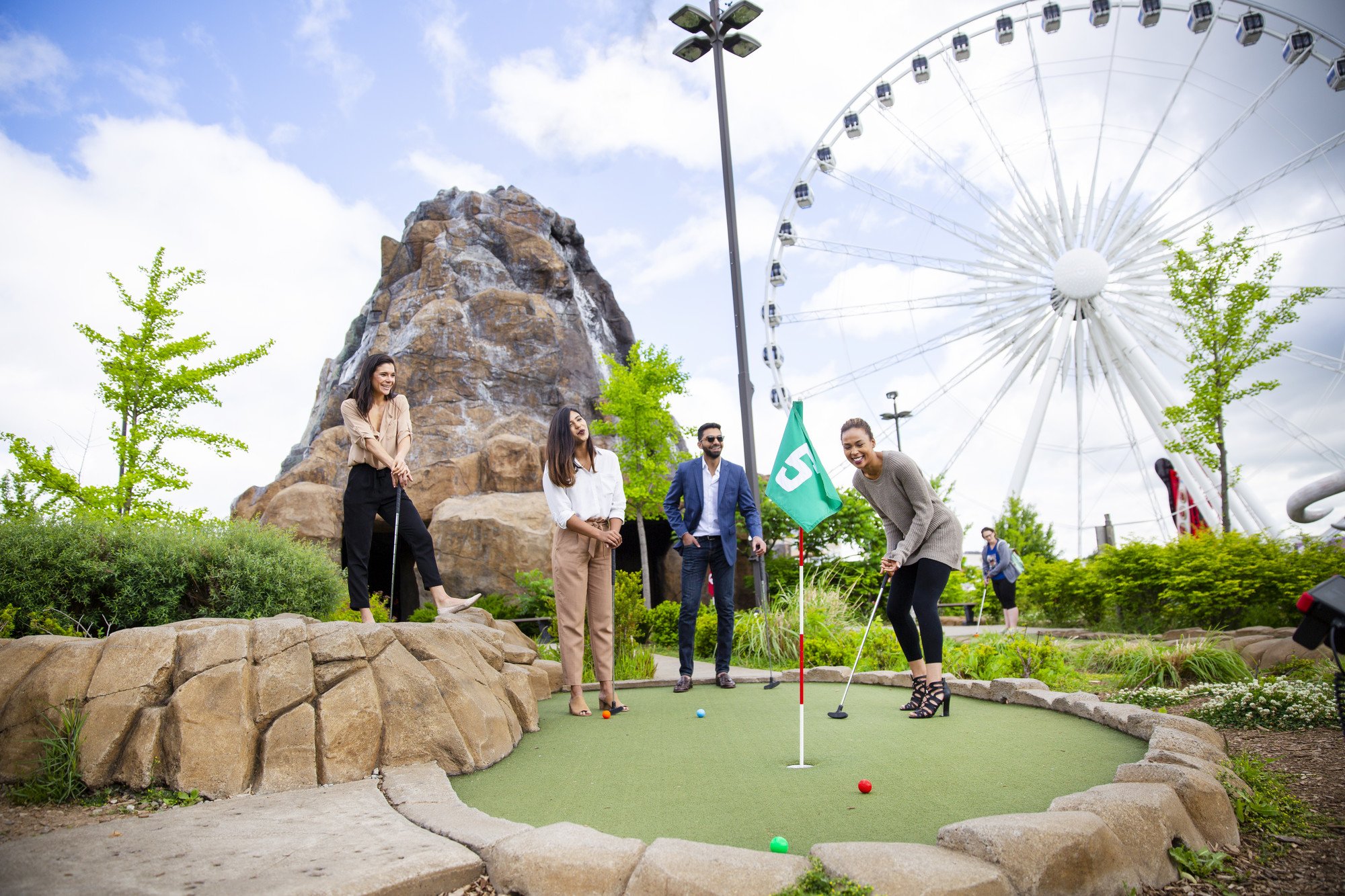 Group of fun couples putting at Dino Adventure Golf