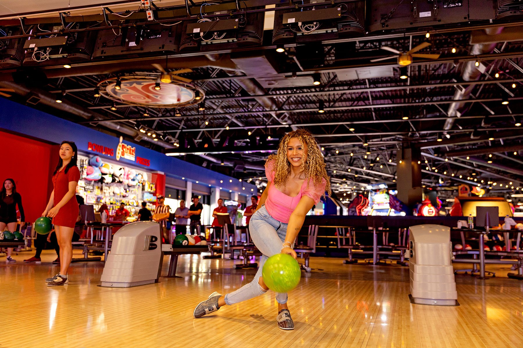 Sending bowling ball down lane at Strike game zone