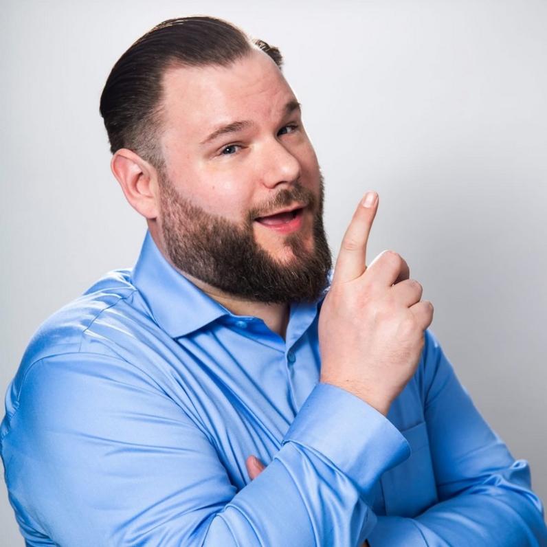 Man in a blue shirt with his index finger raised 