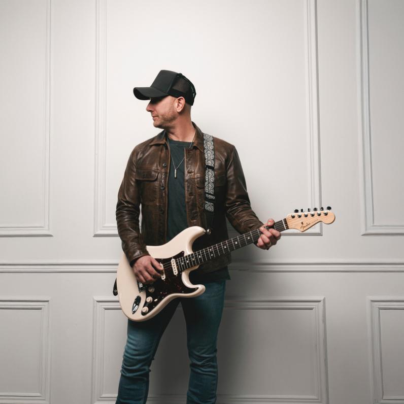 Tim Hicks holding a guitar