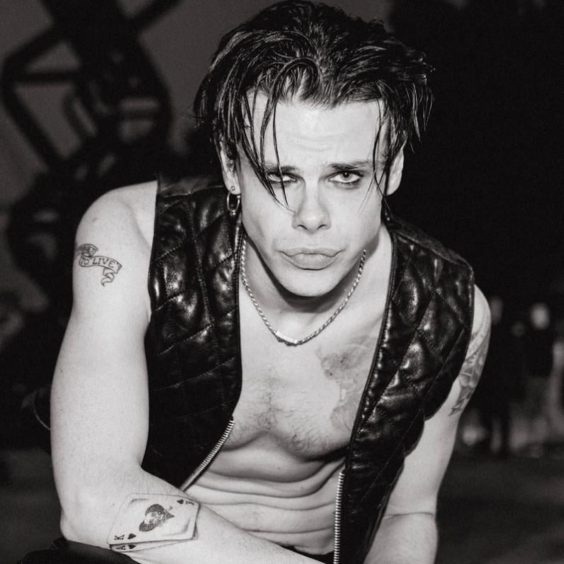 Yungblud wearing a black vest with no shirt on