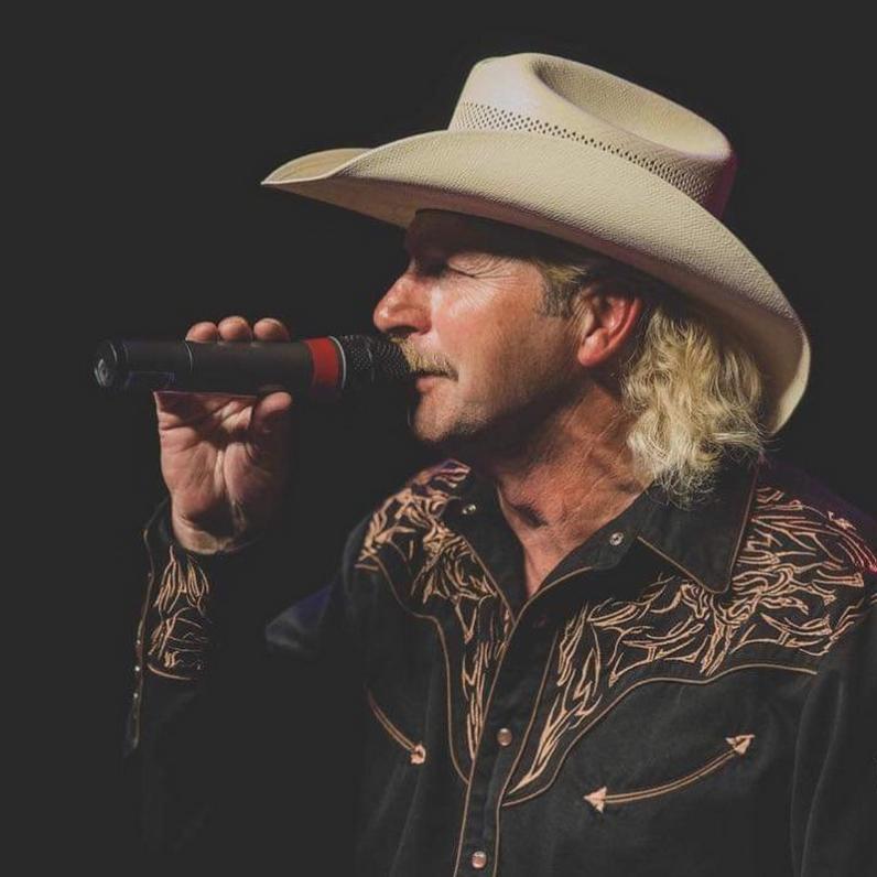 Man with a cowboy hat holding a microphone