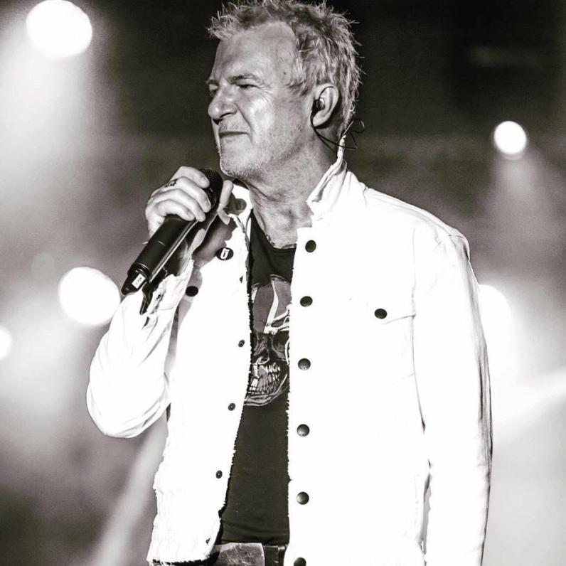 Black and white photo of Alan Frew on stage