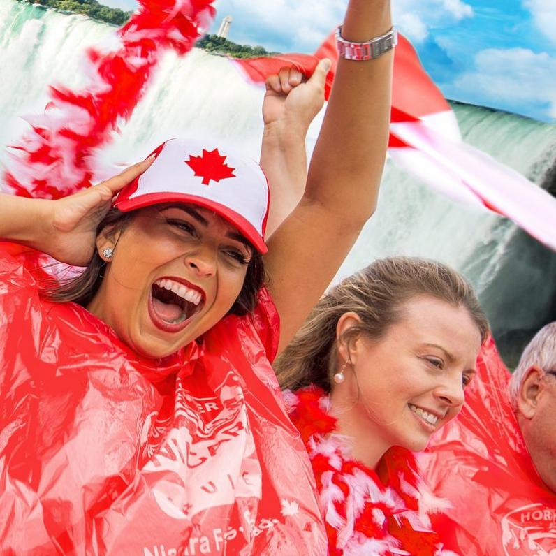 Girl in Canada Day gear and a red poncho standing by the Falls
