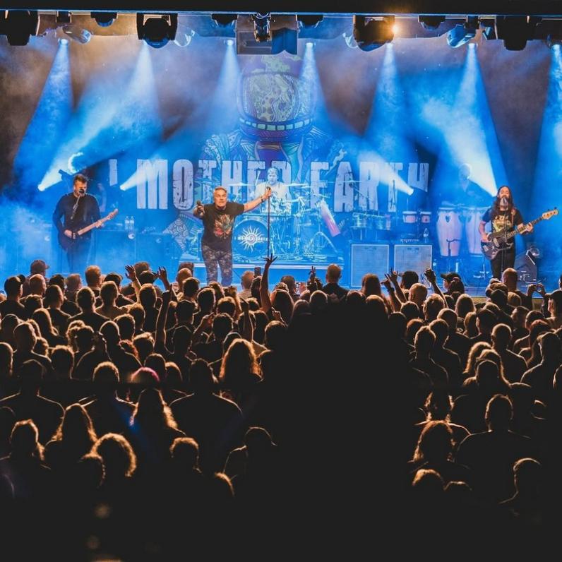 I Mother Earth on stage performing with an audience watching