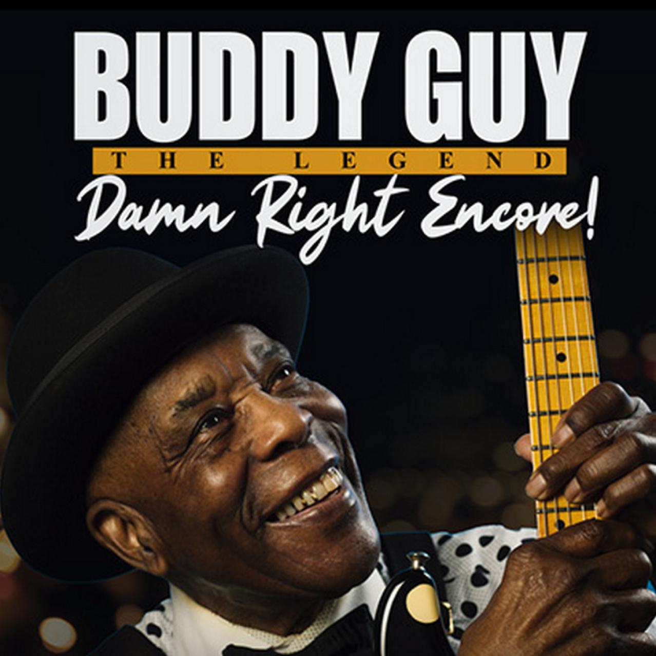 Buddy Guys holding a guitar, wearing a hat