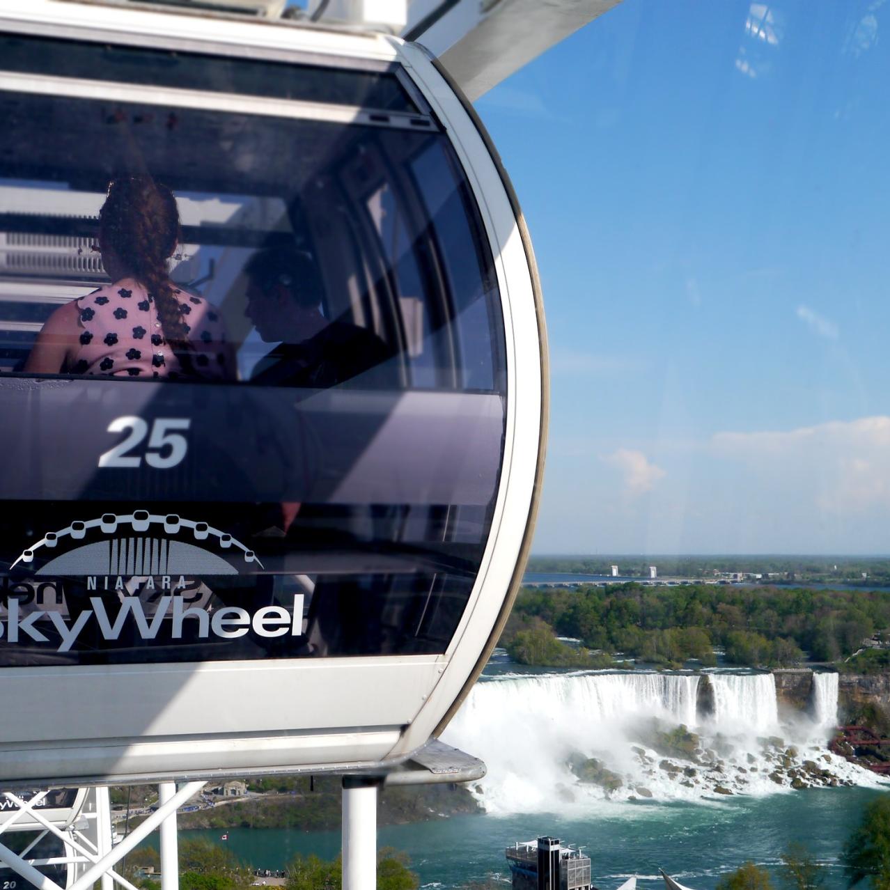 Passenger seated in SkyWheel gondola overlooking the falls on a clear day
