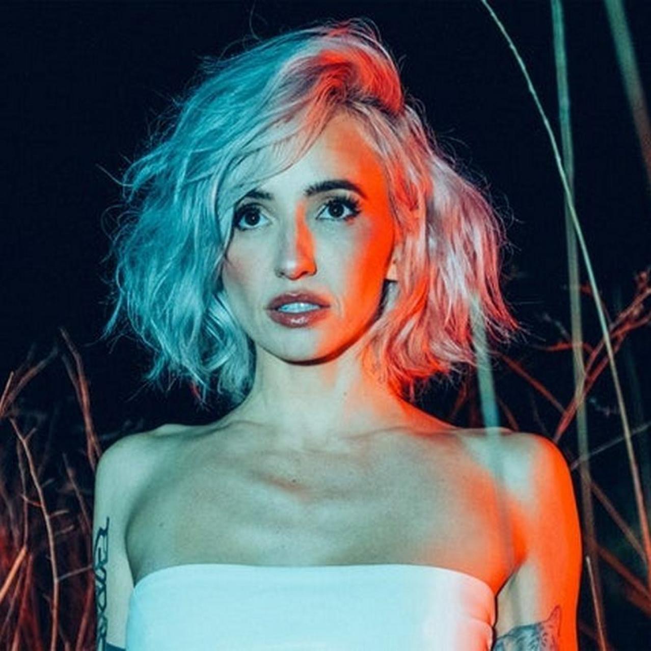 Lights with short blonde hair in a white top