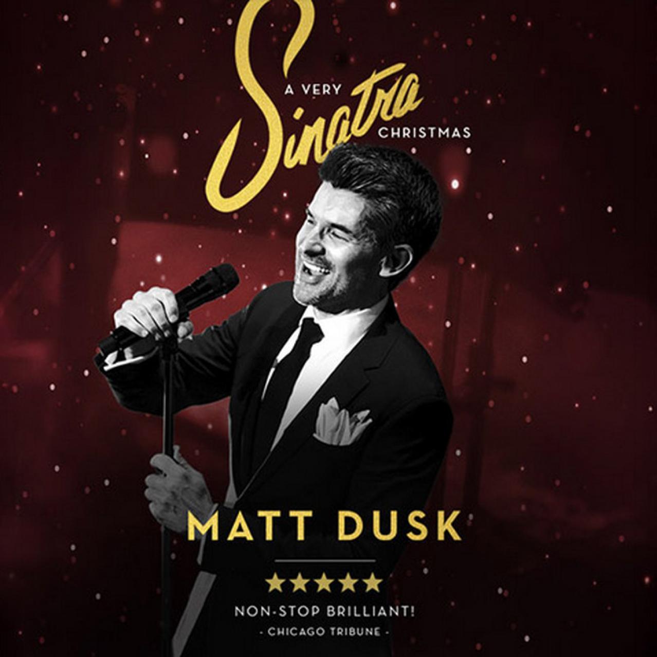 Matt Dusk in a suit holding a microphone and smiling