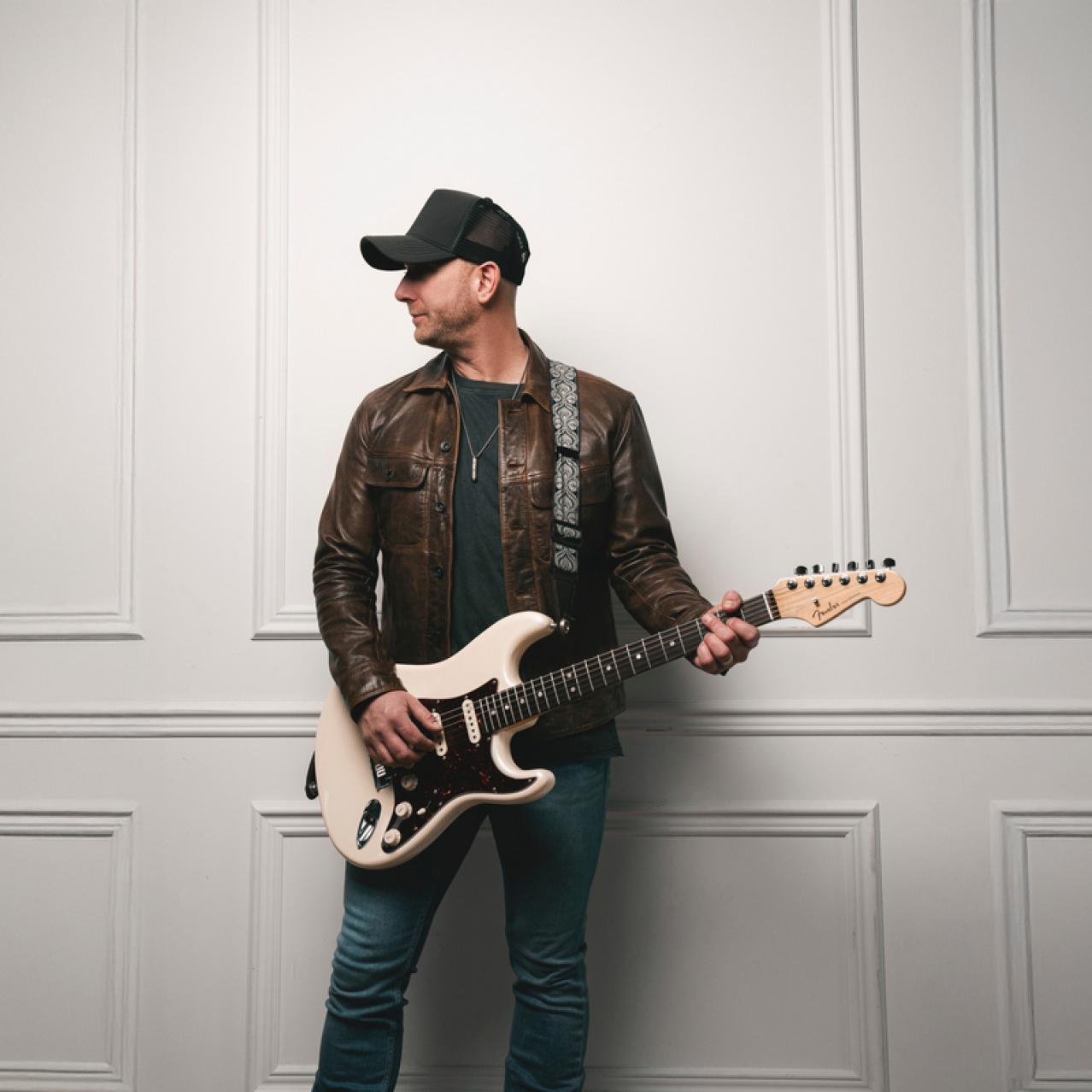Tim Hicks holding a guitar