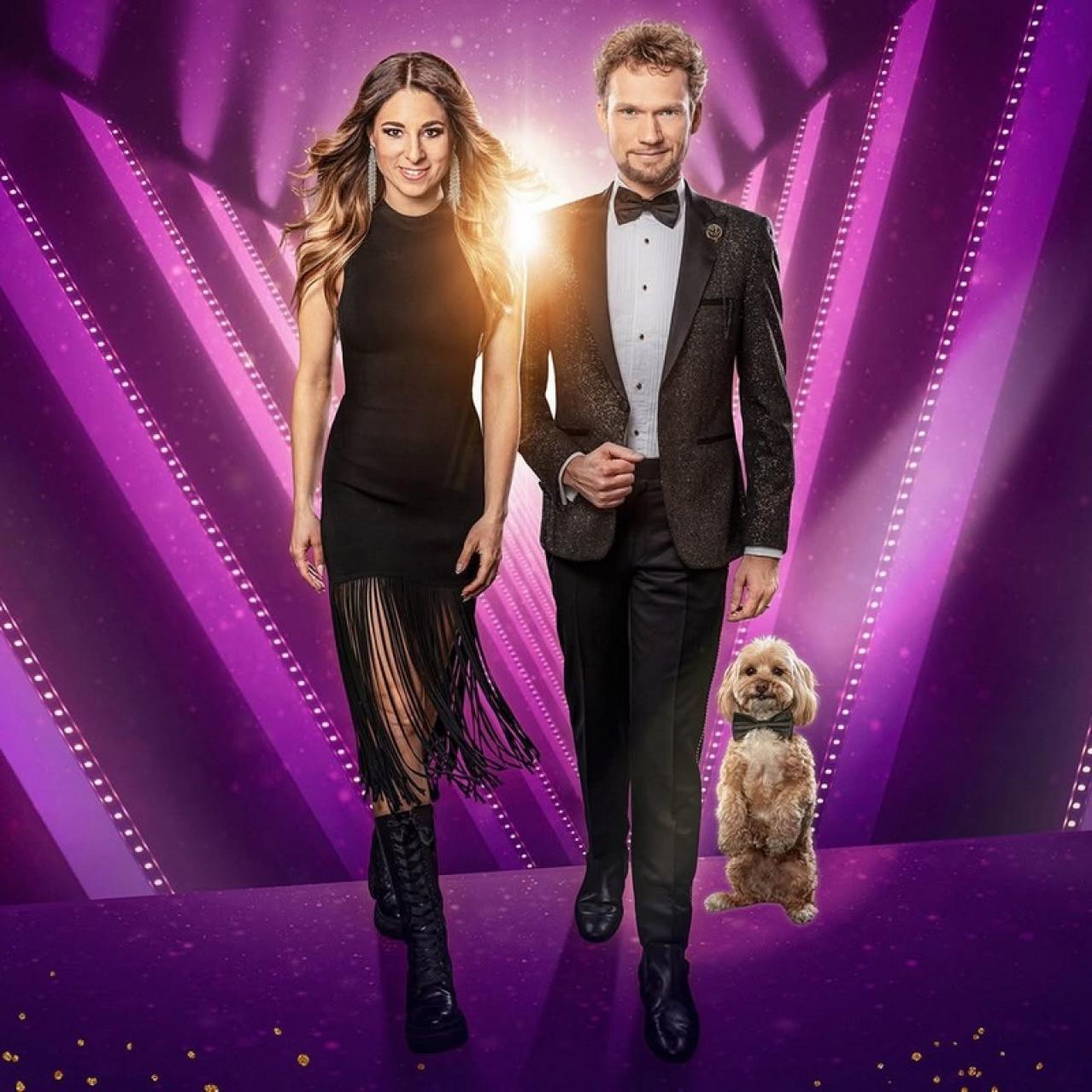 Man and woman dressed in formal black attire with a dog to their left side