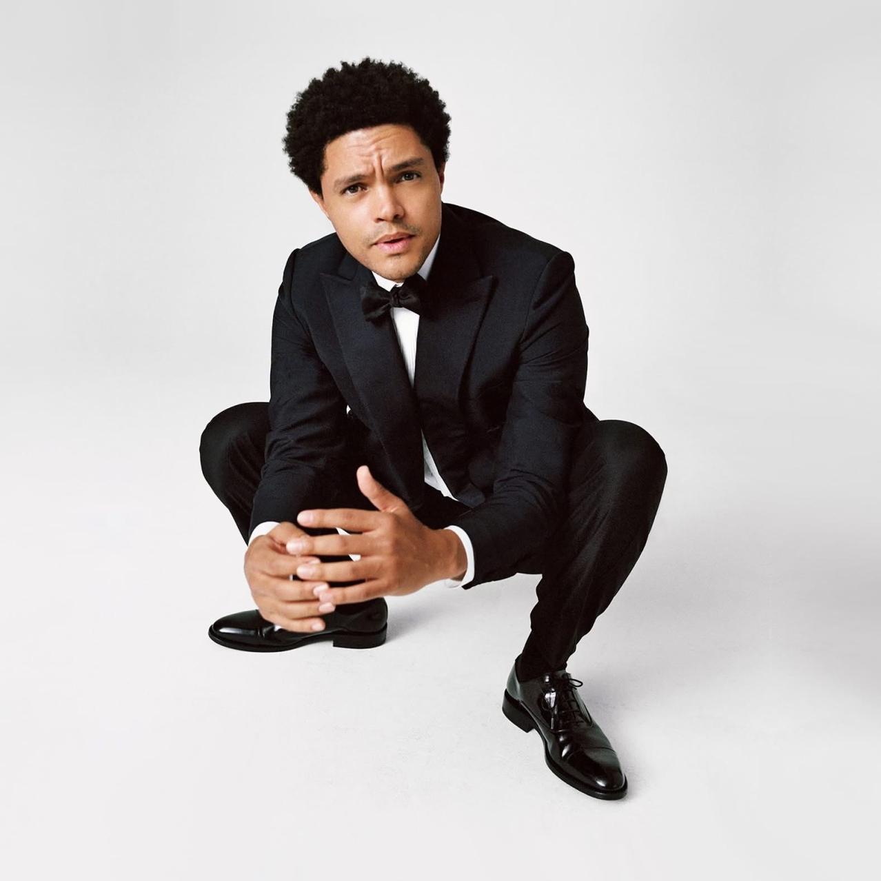 squatting in a black suit