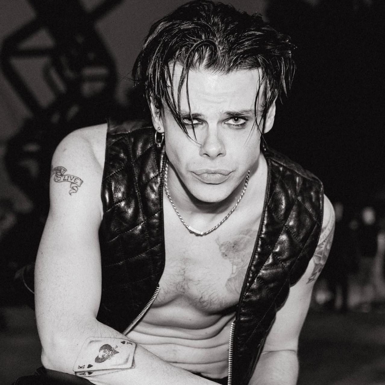Yungblud wearing a black vest with no shirt on