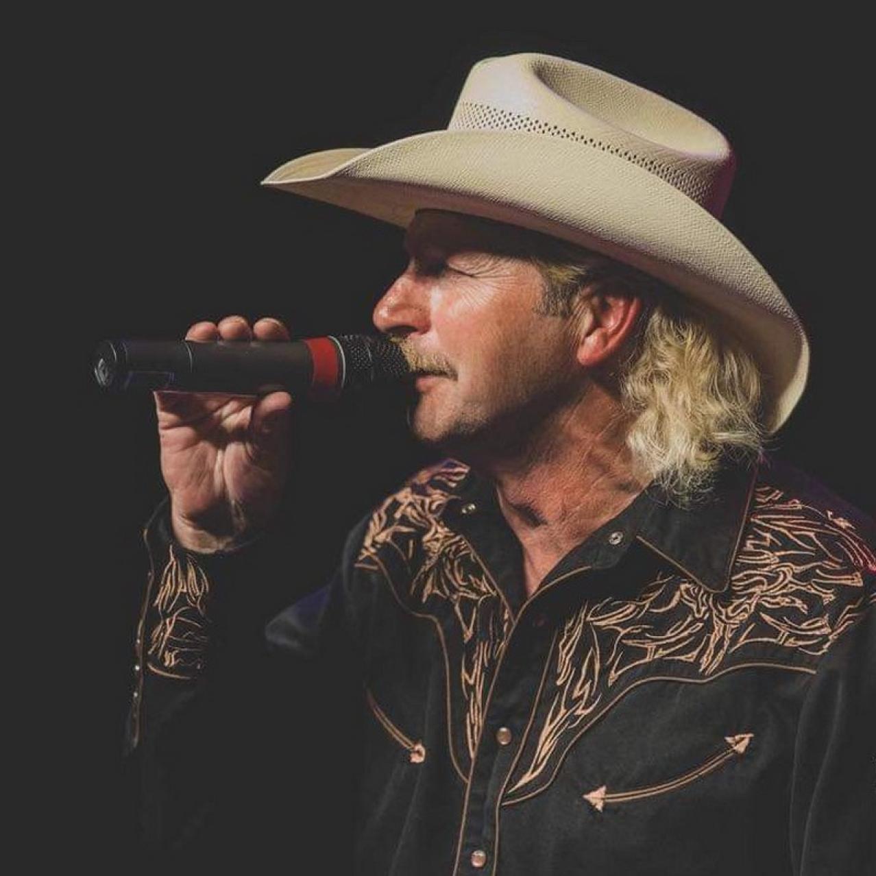 Man with a cowboy hat holding a microphone