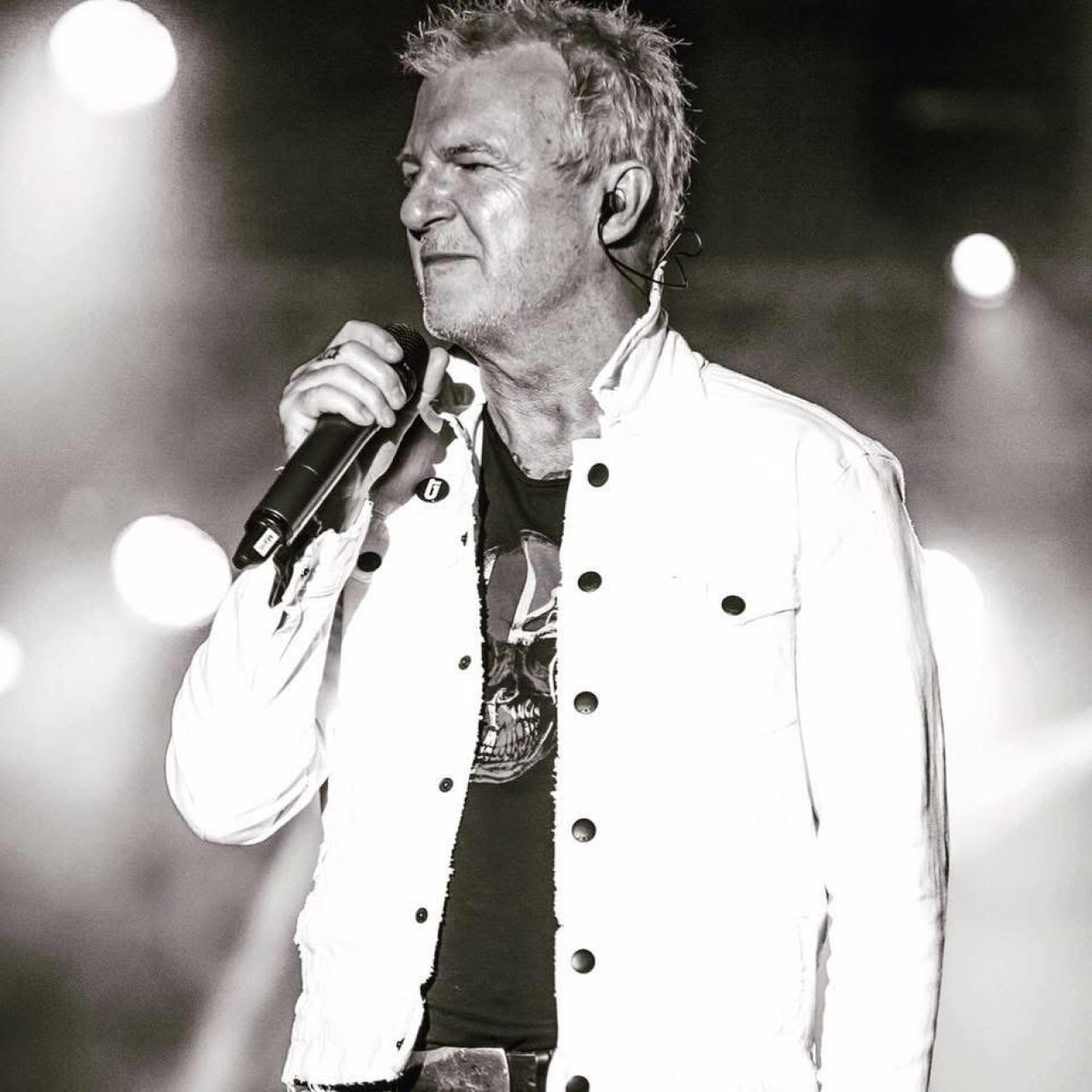 Black and white photo of Alan Frew on stage