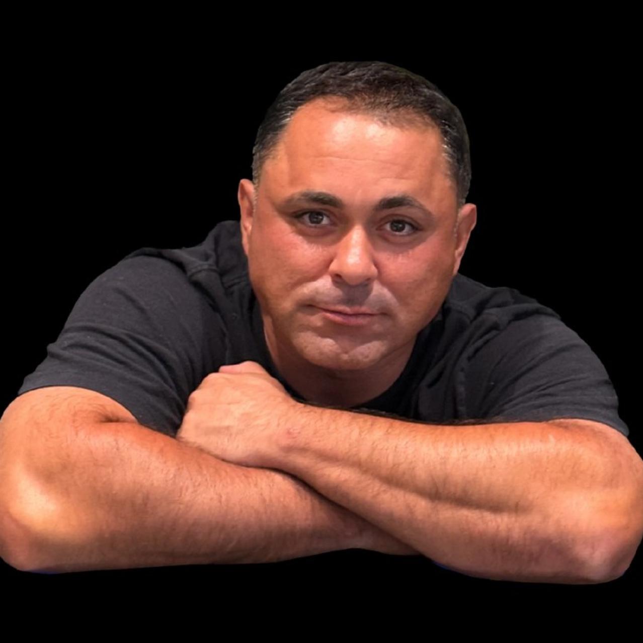Anthony Rodia with his arms crossed and a black background