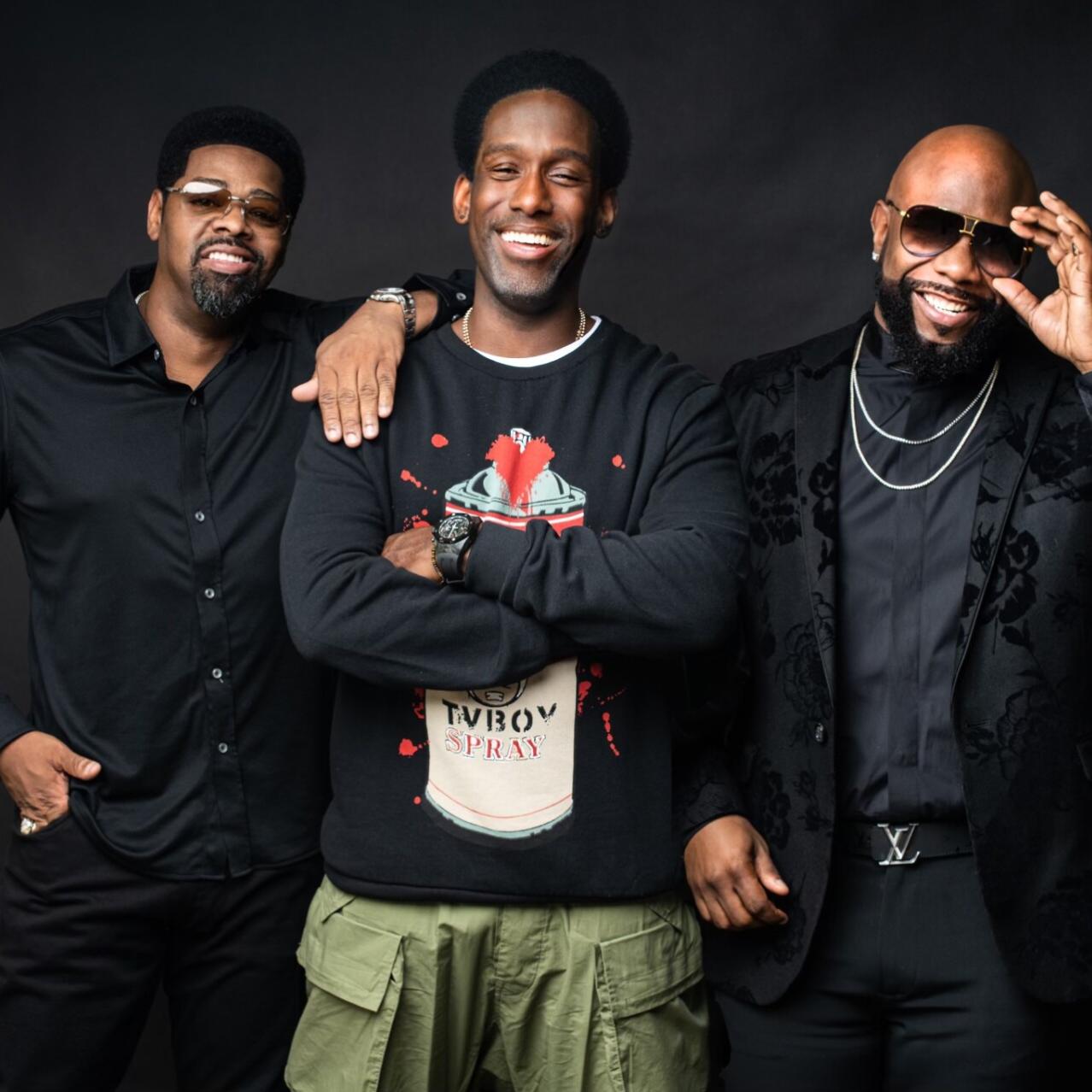 Trio standing smiling with a black backdrop
