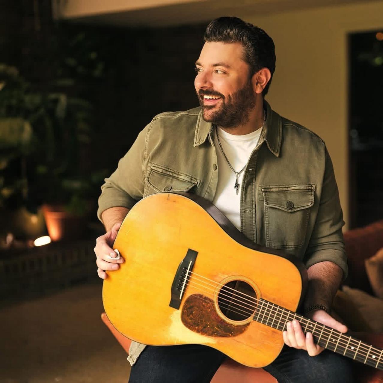 Chris Young holding a guitar smiling
