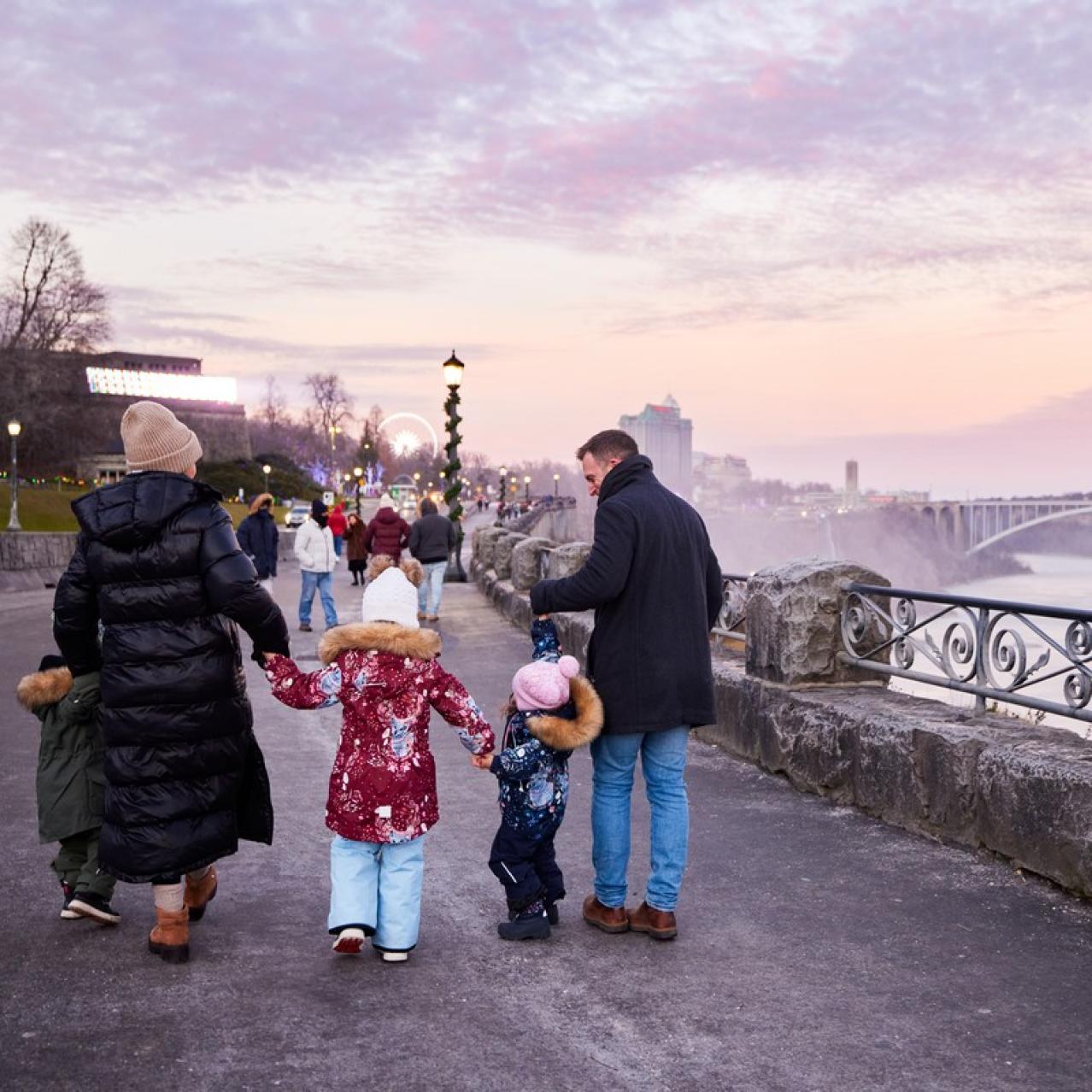 Family walking along the parkway with the SkyWheel in the distance