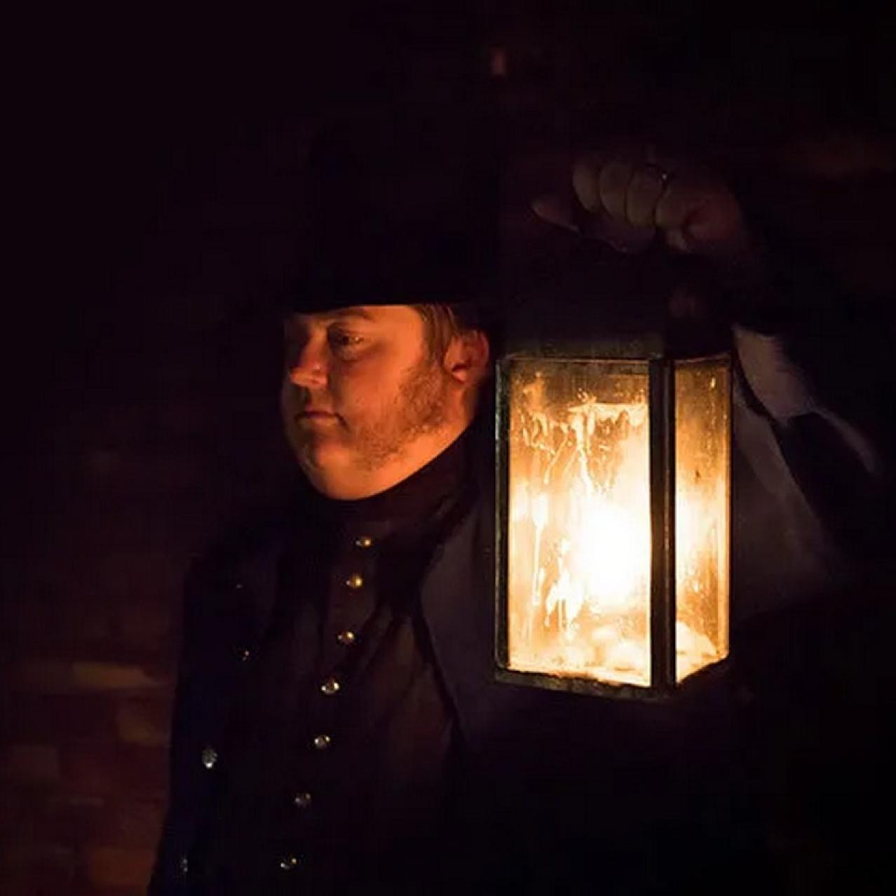 Man holding a candle lit lantern