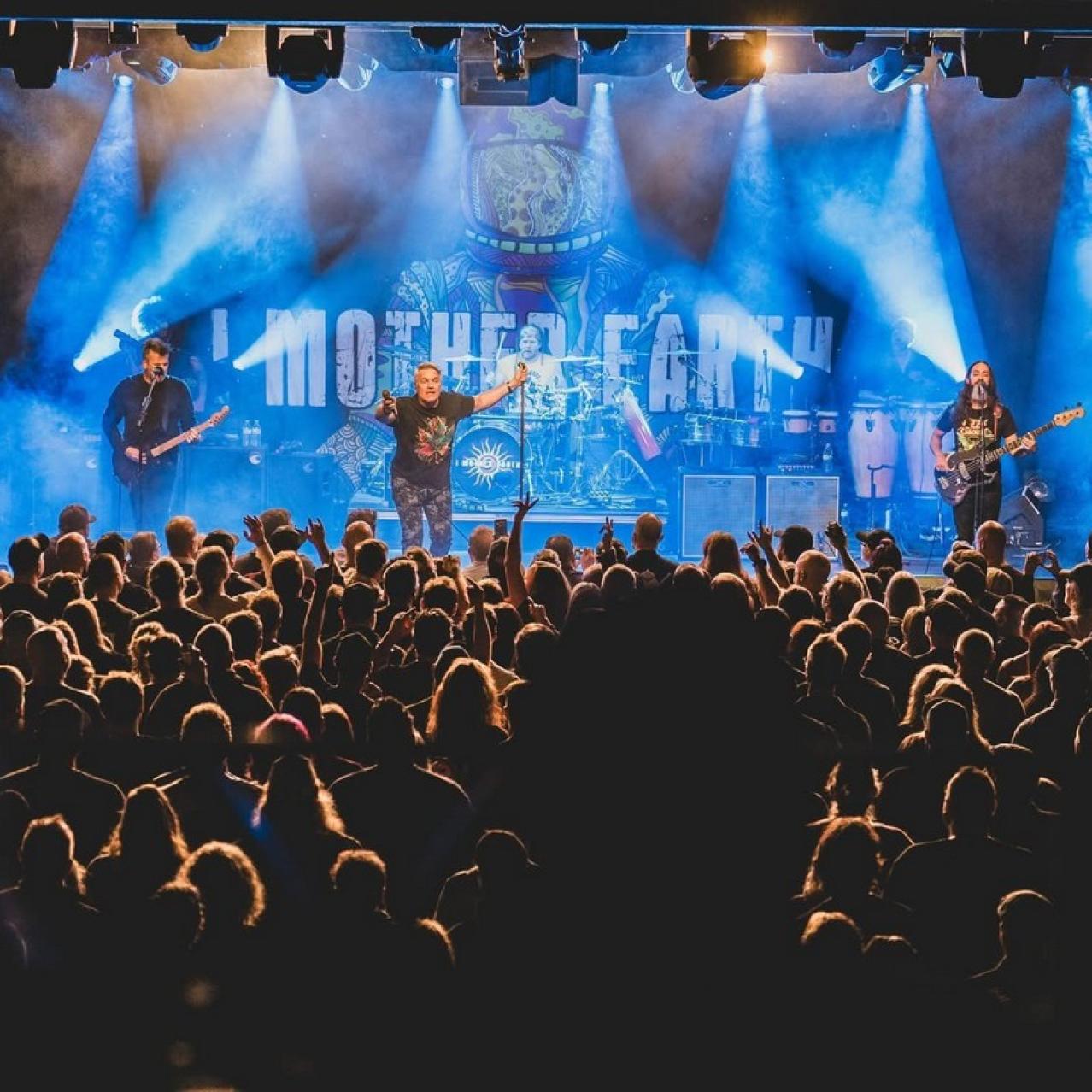 I Mother Earth on stage performing with an audience watching