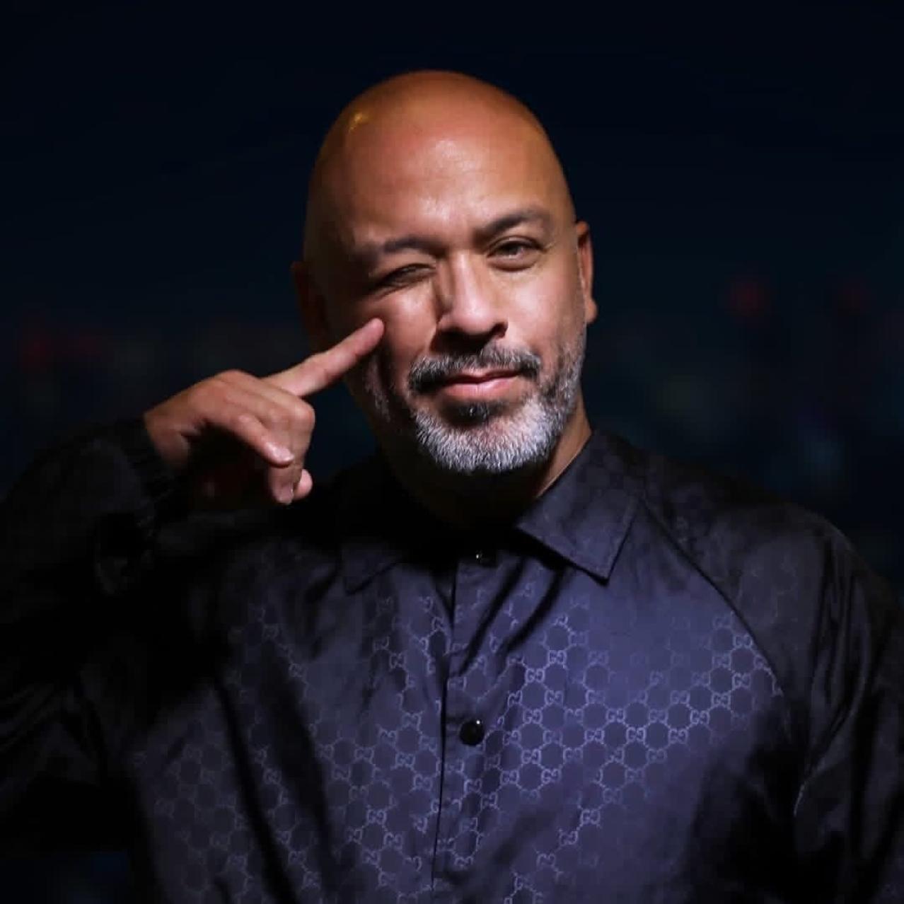 Jo Koy with his finger pressed up against his cheek