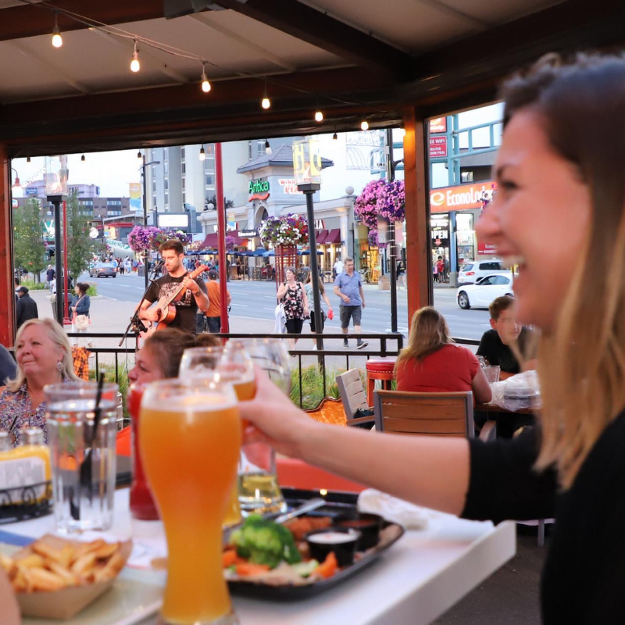 Girl sitting laughing on the patio with live music in the background
