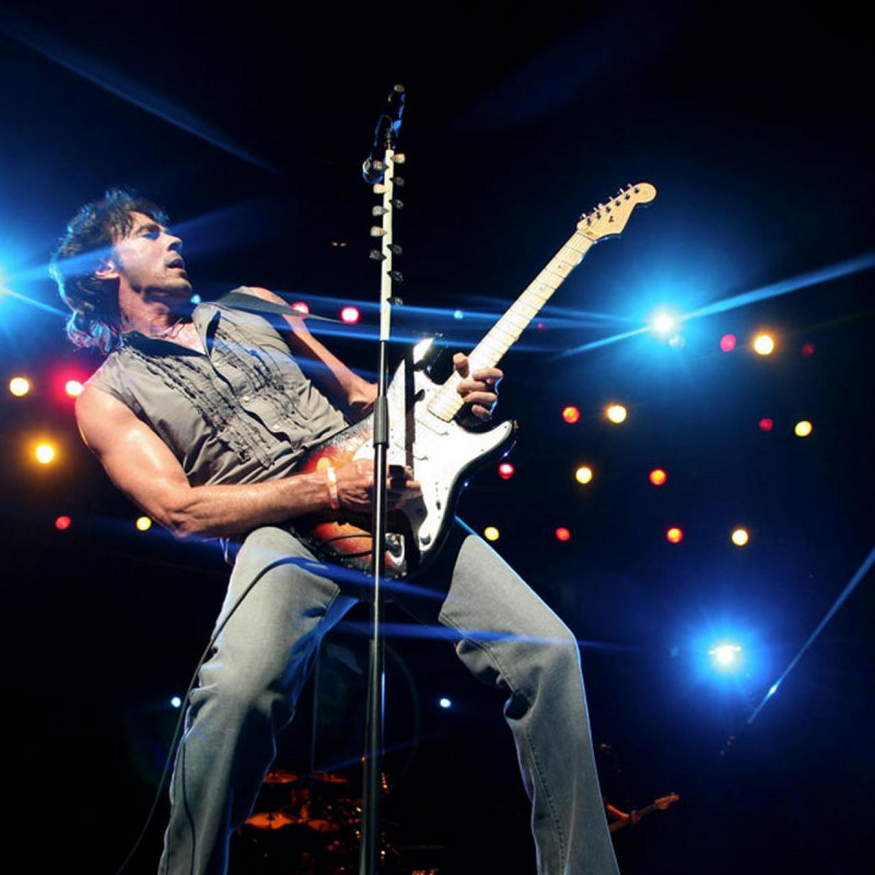 Rick Springfield on stage playing guitar