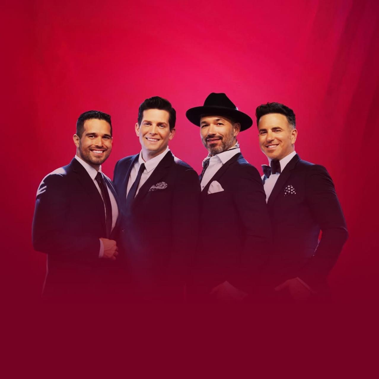 The Tenors dressed in suits with red fog surrounding them 