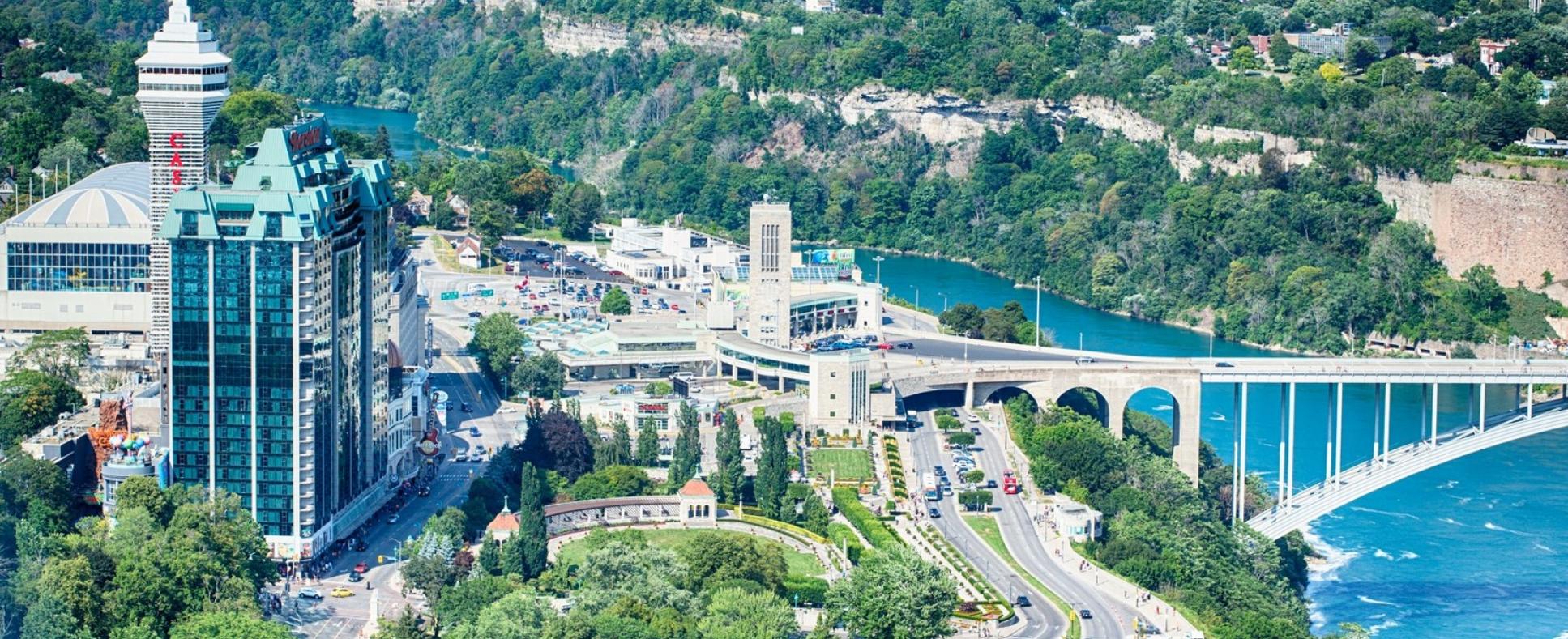 View of the Rainbow Bridge entering into Canada with the Sheraton, Casino Niagara, Fallsview Waterpark, and Oakes Garden in the shot