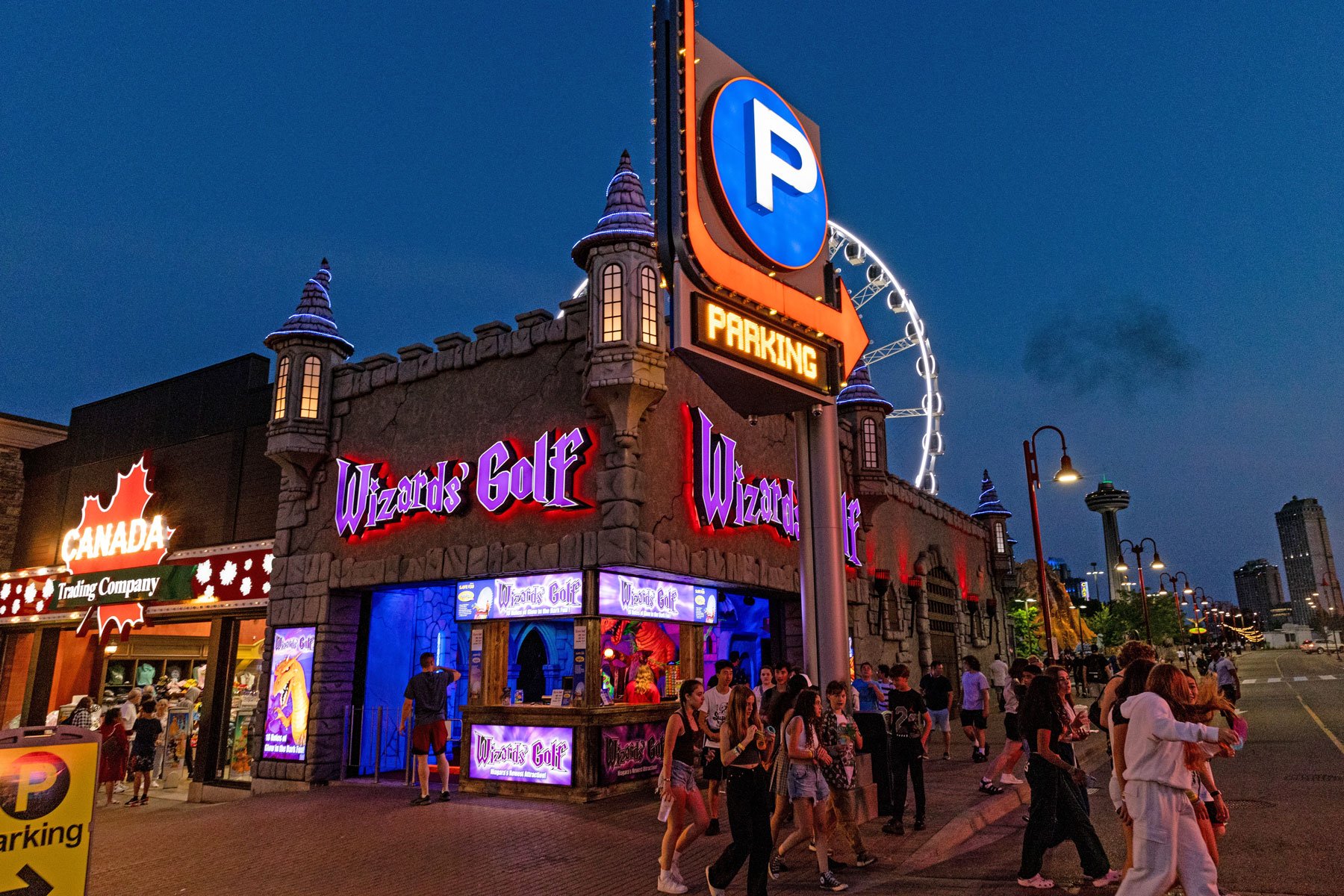 Wizards golf entrance at night with group of people congregating