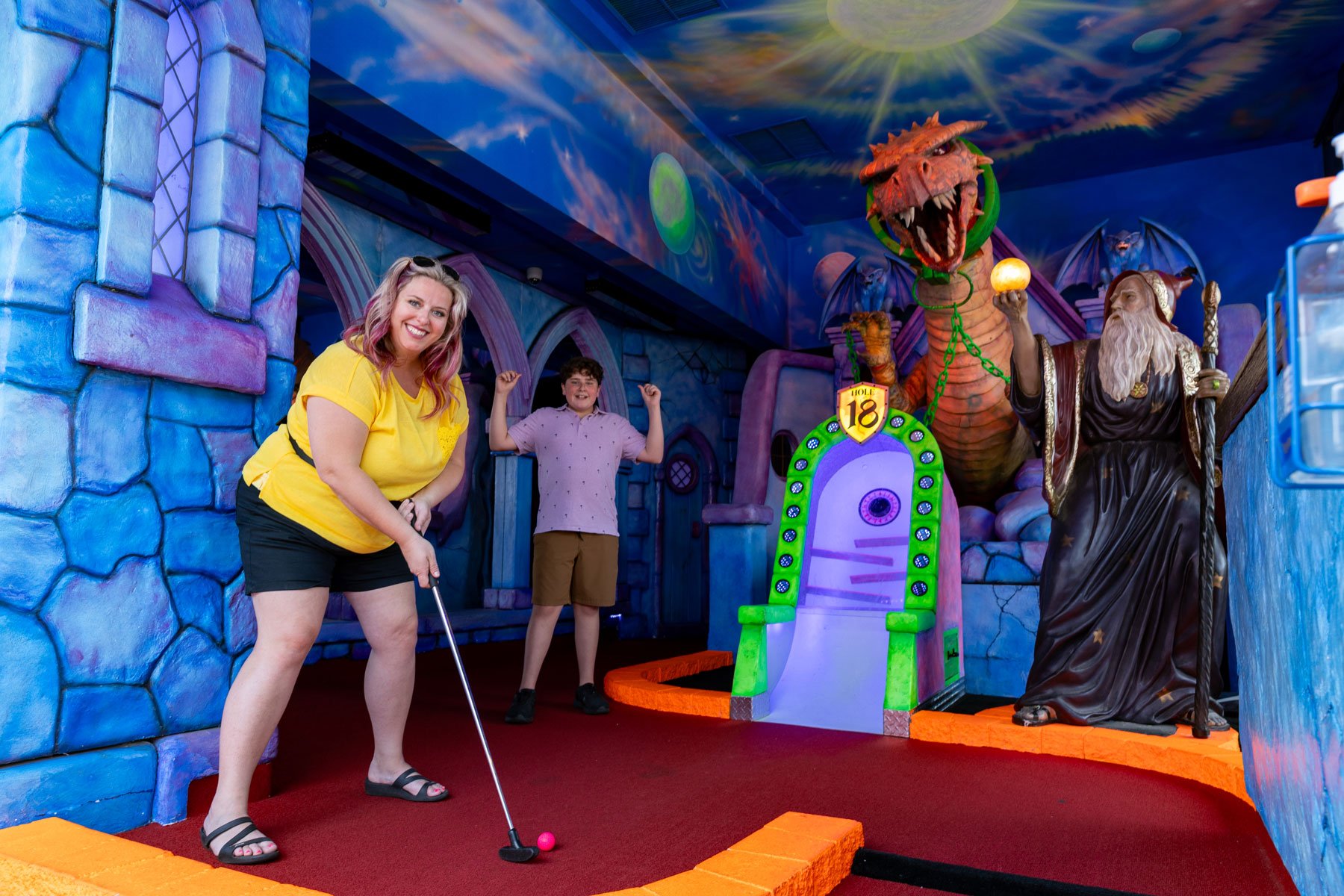 Mom and son putting in Wizards Golf Entrance